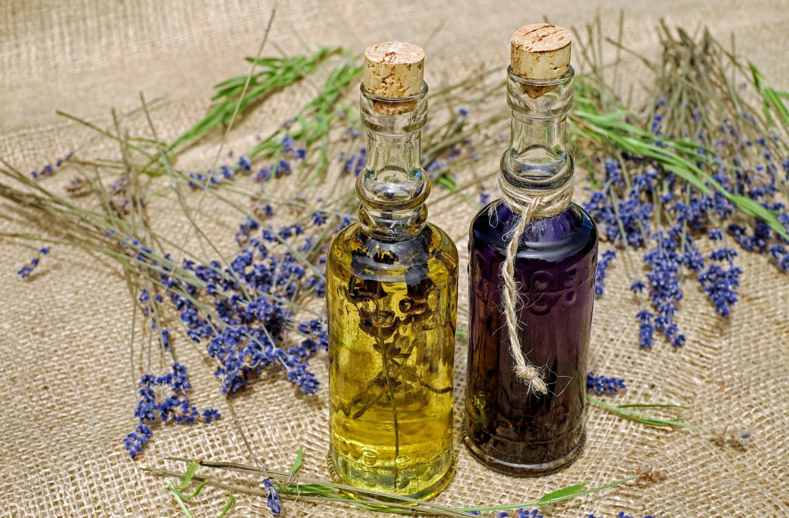 Mazzetto di lavanda secca accanto a mezzo limone e a una boccetta di vetro trasparente