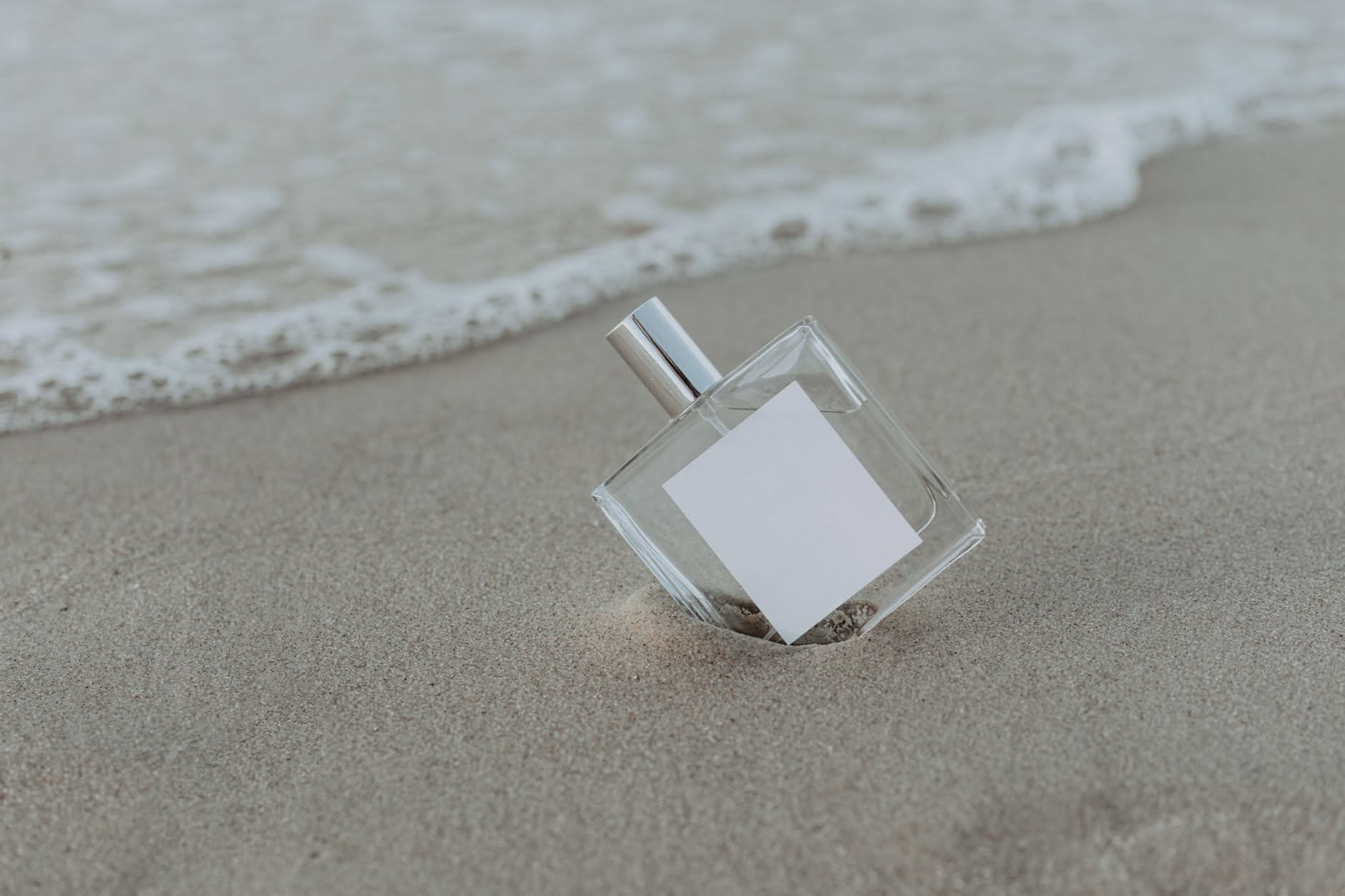 Tubetto di crema solare e flacone di profumo su telo da spiaggia con luce estiva